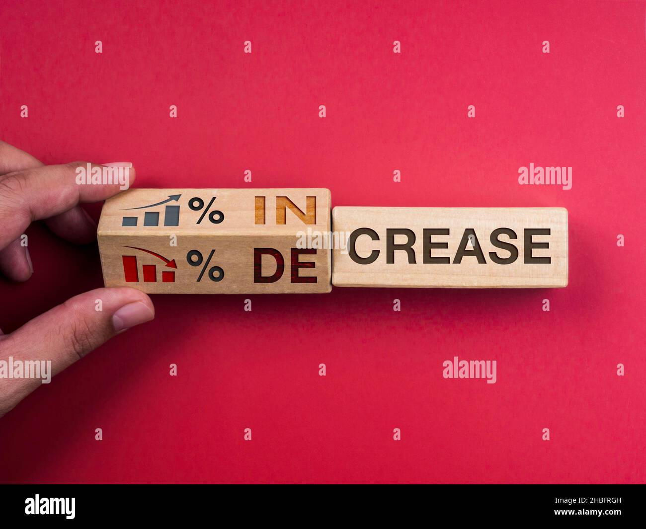 Ridurre e aumentare il concetto di business in percentuale. Le parole 'AUMENTANO' sul blocco di legno che passa a 'DECREASE', girando a mano con il simbolo di percentuale, gr Foto Stock
