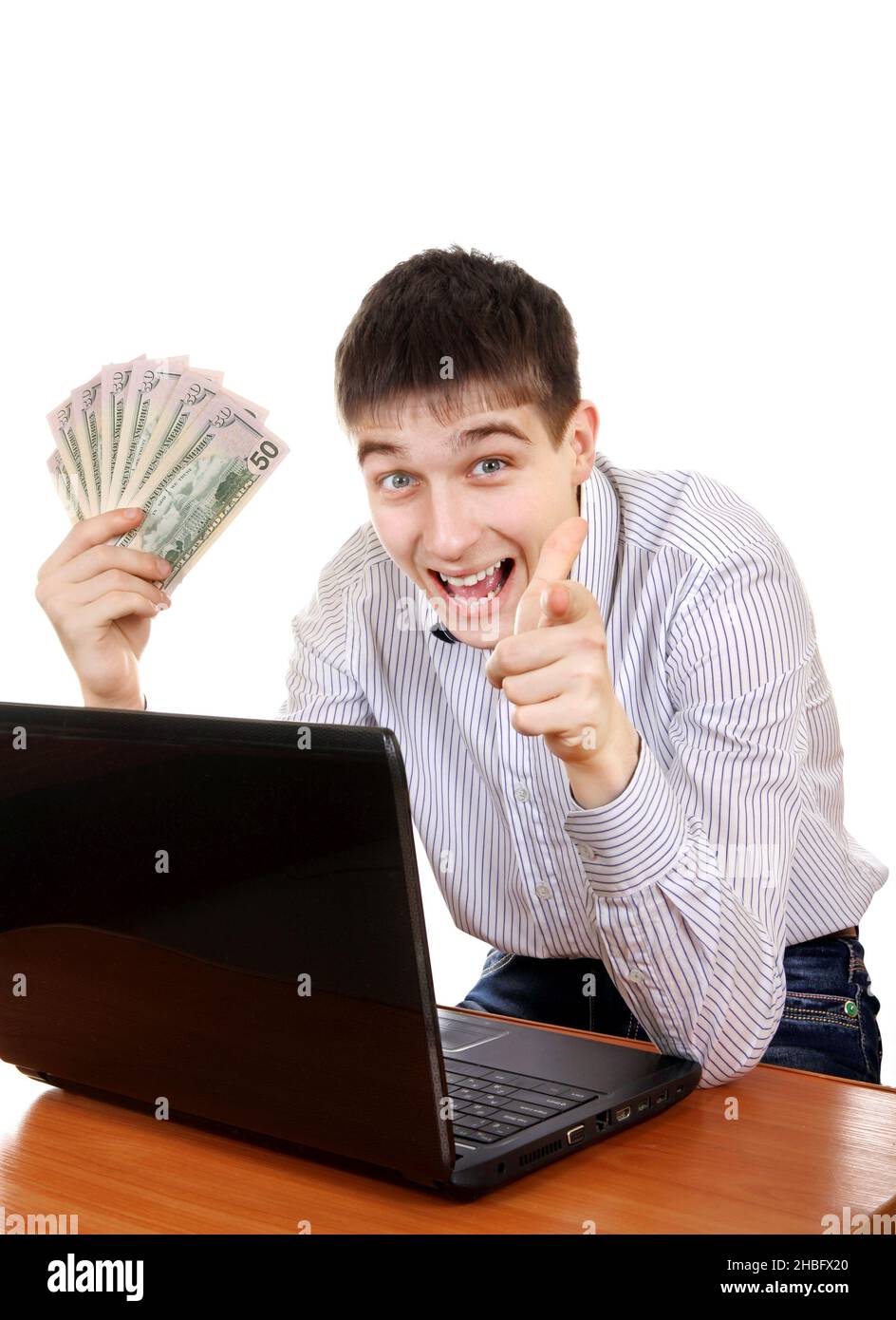 Buon adolescente con laptop e denaro che ti indica sullo sfondo bianco Foto Stock