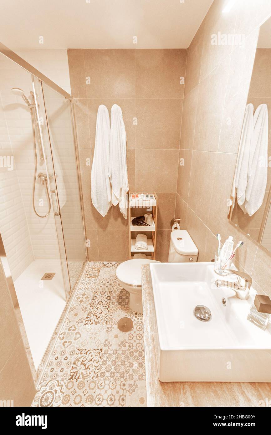 Bagno con doccia, wc e lavandino con specchio dall'hotel Foto Stock