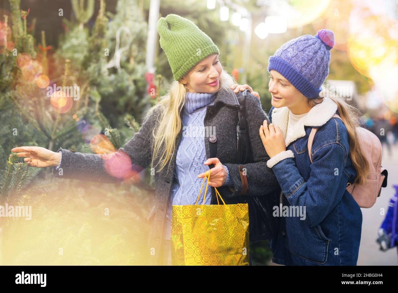 Madre e figlia adolescente che sceglie l'albero di Natale alla fiera di Natale Foto Stock
