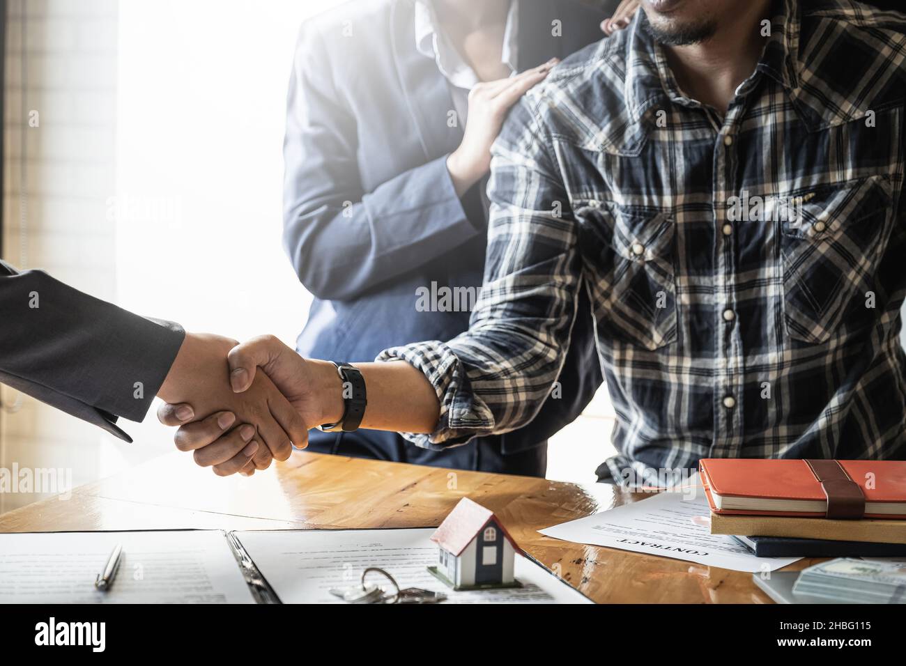 Incontro di agente e coppia e handshaking dopo un buon affare per acquistare casa. Accordo e concetto di bene immobile. Foto Stock