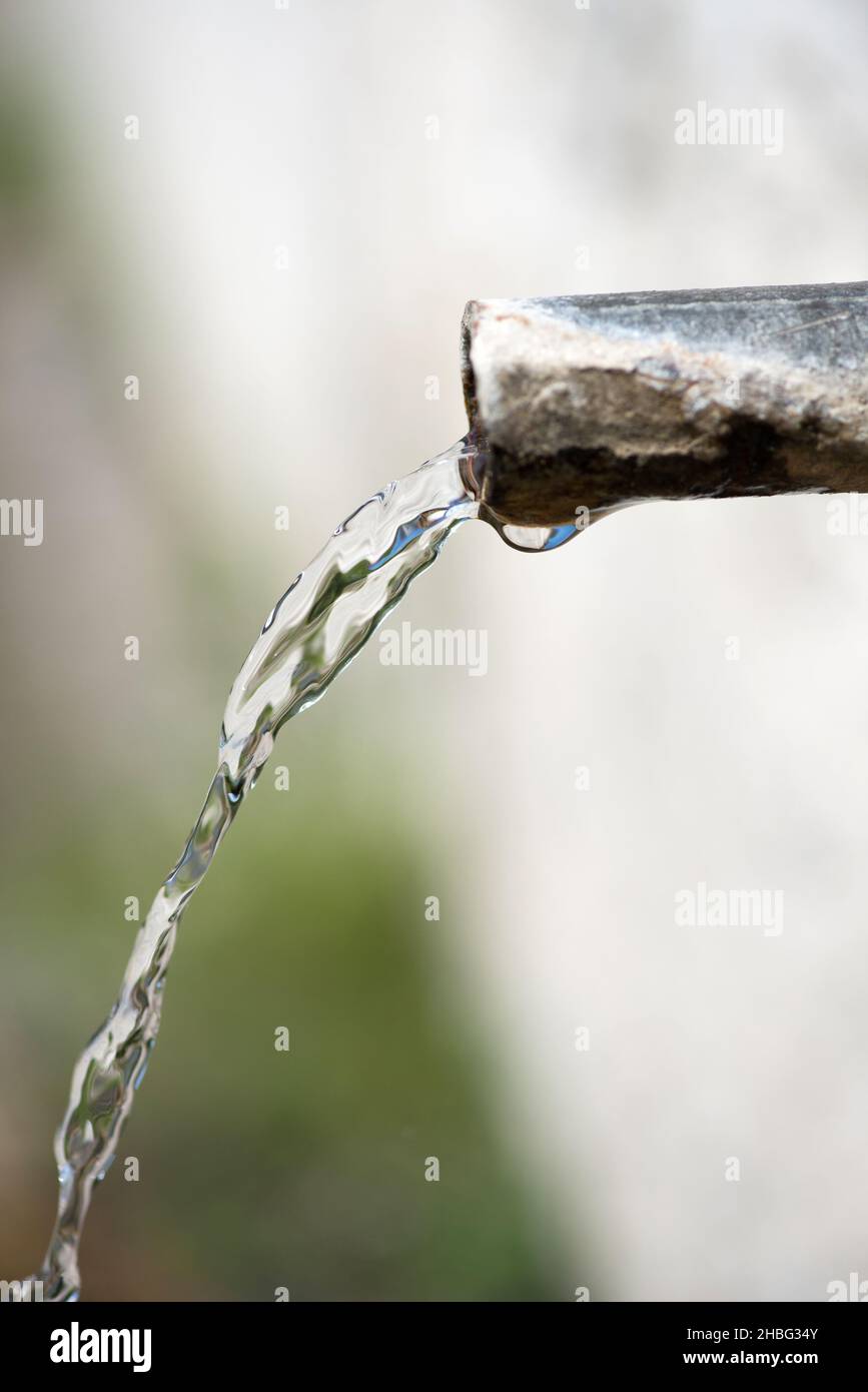 Primo piano di un beccuccio in corrispondenza di una fontana a lato della strada - messa a fuoco selettiva Foto Stock