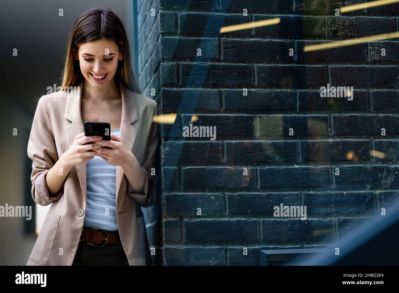 Ritratto di donna di successo con mobile in background urbano. Concetto di dispositivi tecnologici aziendali Foto Stock