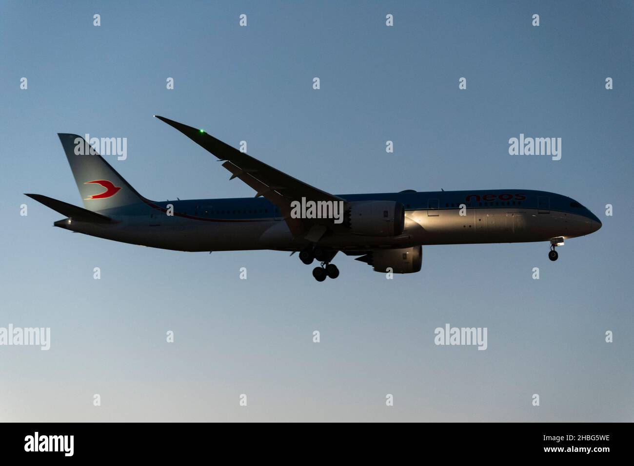 Neos Boeing 787 aereo di linea Dreamliner in avvicinamento per atterrare all'aeroporto di Londra Heathrow, Regno Unito, in cielo chiaro crepuscolo. Arrivo notturno con i rifugiati afghani Foto Stock