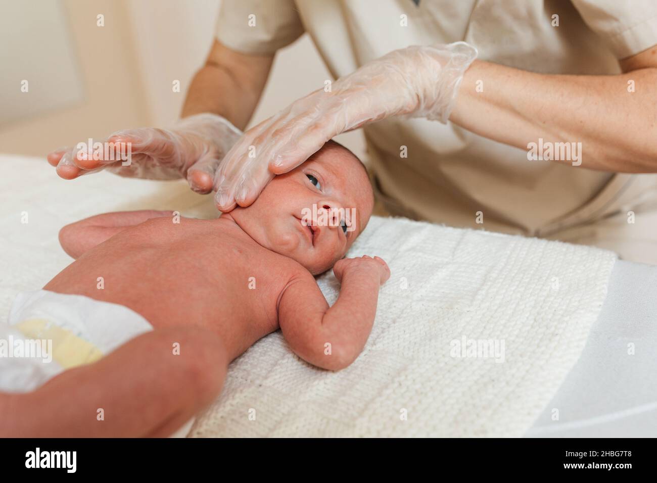 Fisioterapista che esegue la fascia cervicale superficiale in un neonato. Foto Stock