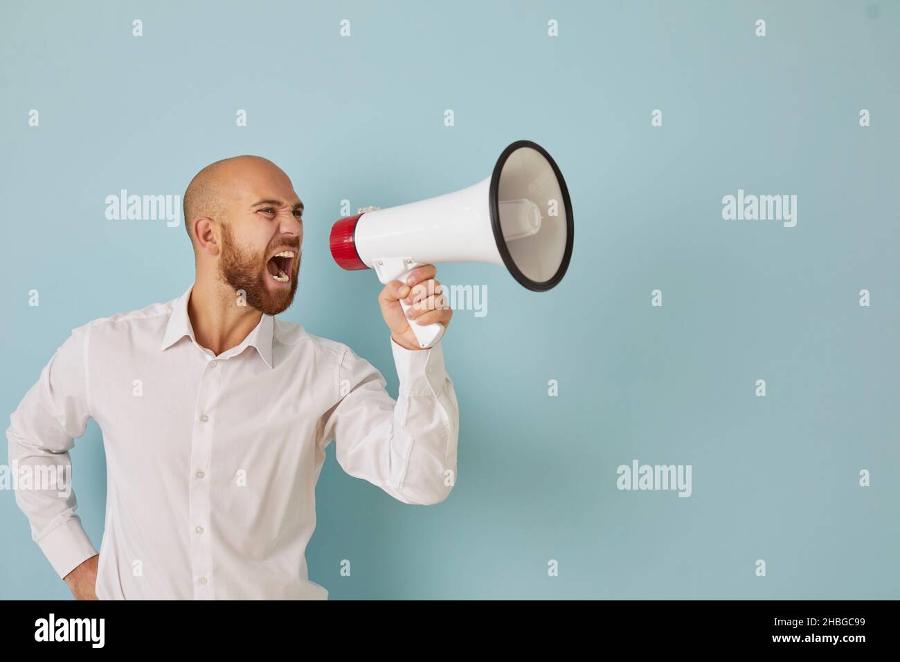 Un uomo d'affari insoddisfatto e arrabbiato fa un forte annuncio urlando in altoparlante. Foto Stock