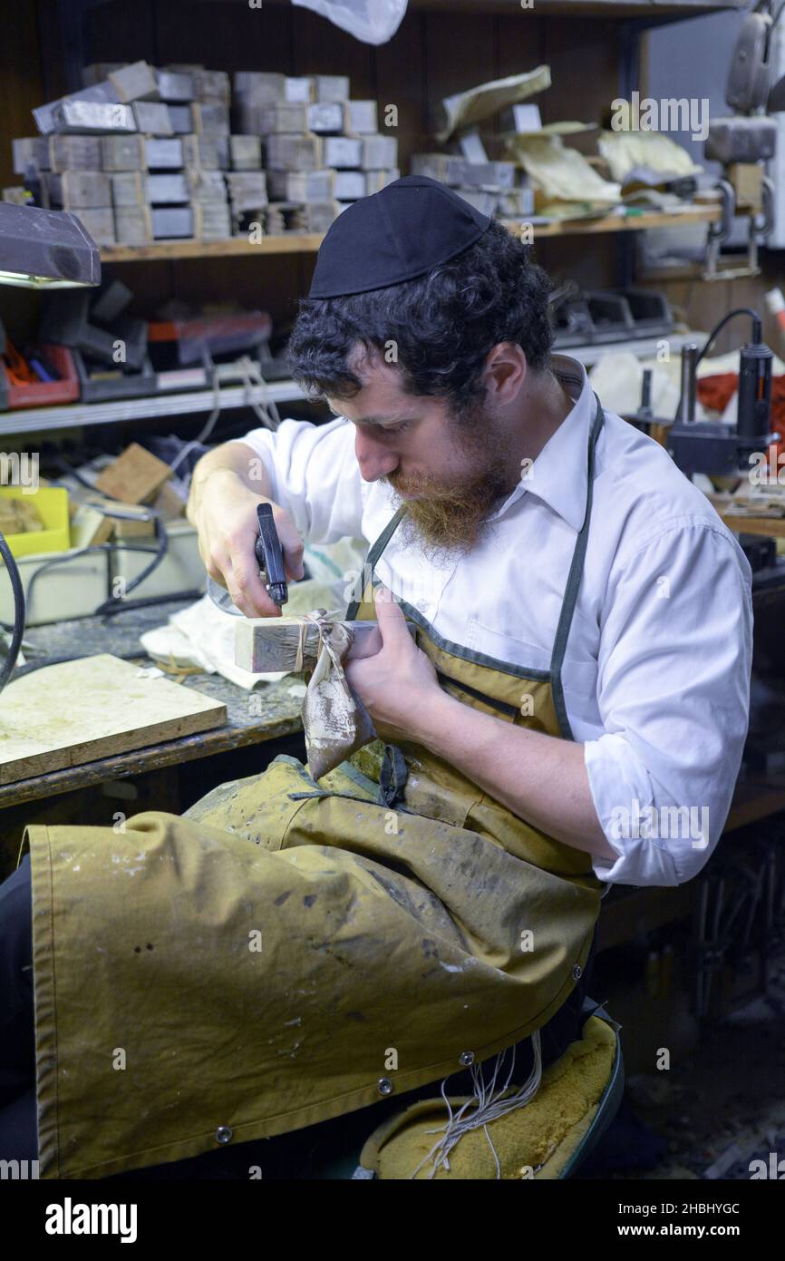 Un rabbino ortodosso fa le scatole di tefillin nel suo laboratorio di seminterrato usando i metodi e gli attrezzi vecchi dell'età. A Brooklyn, New York. Foto Stock