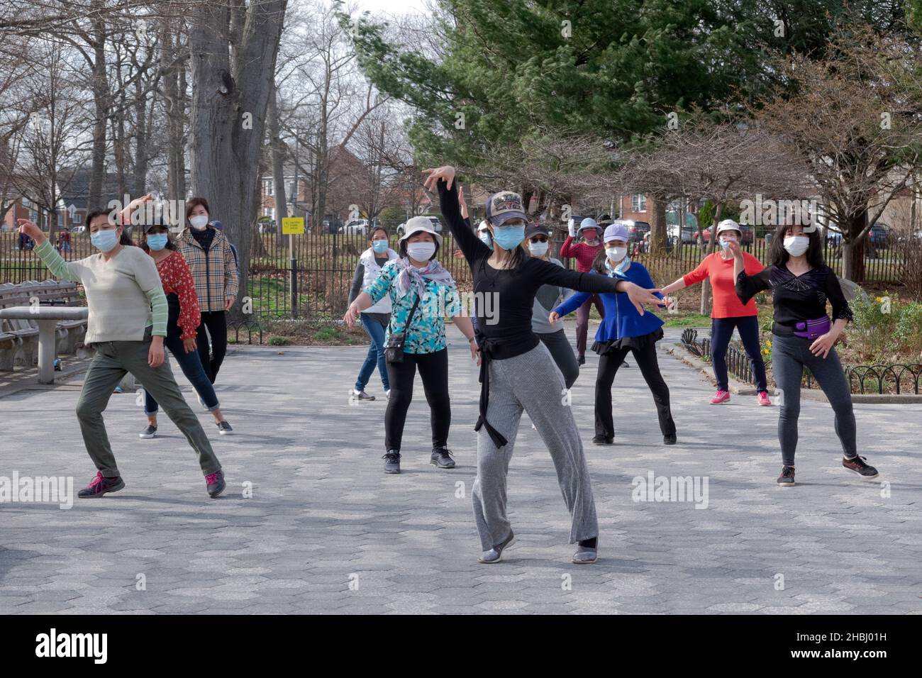 Un gruppo di donne cinesi americane mascherate di varie età in una lezione di danza in un parco a Queens, New York. Foto Stock