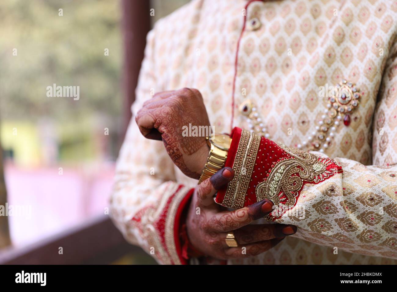 Primo piano delle mani di uno sposo indiano che indossa sherwani intrecciati e un orologio sulla mano sul matrimonio Foto Stock Primo piano delle mani di uno sposo indiano che indossa sherwani intrecciati e un orologio sulla mano sul matrimonio Foto Stock
