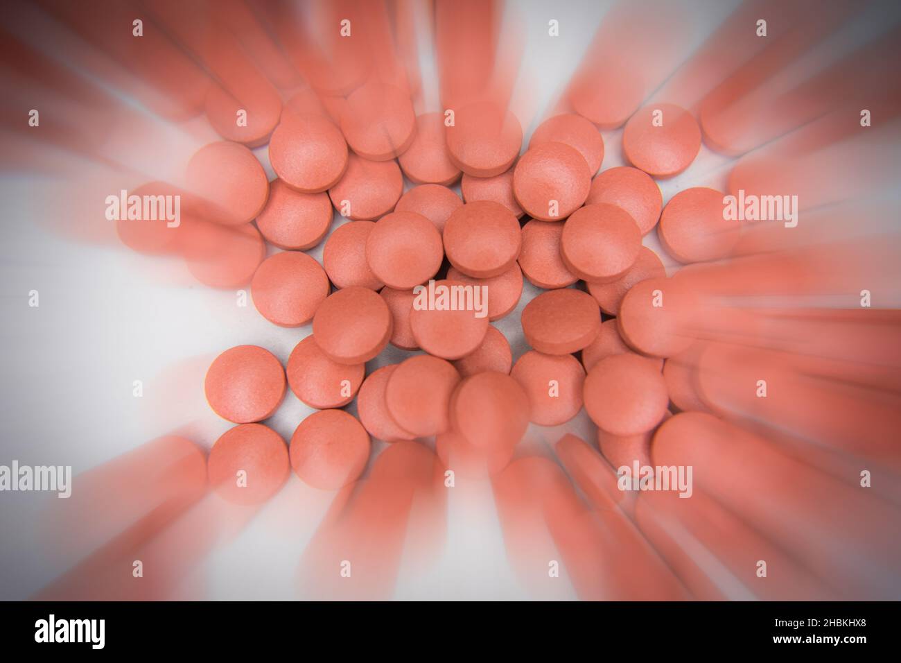 mucchio di pillole rosse su sfondo bianco Foto Stock