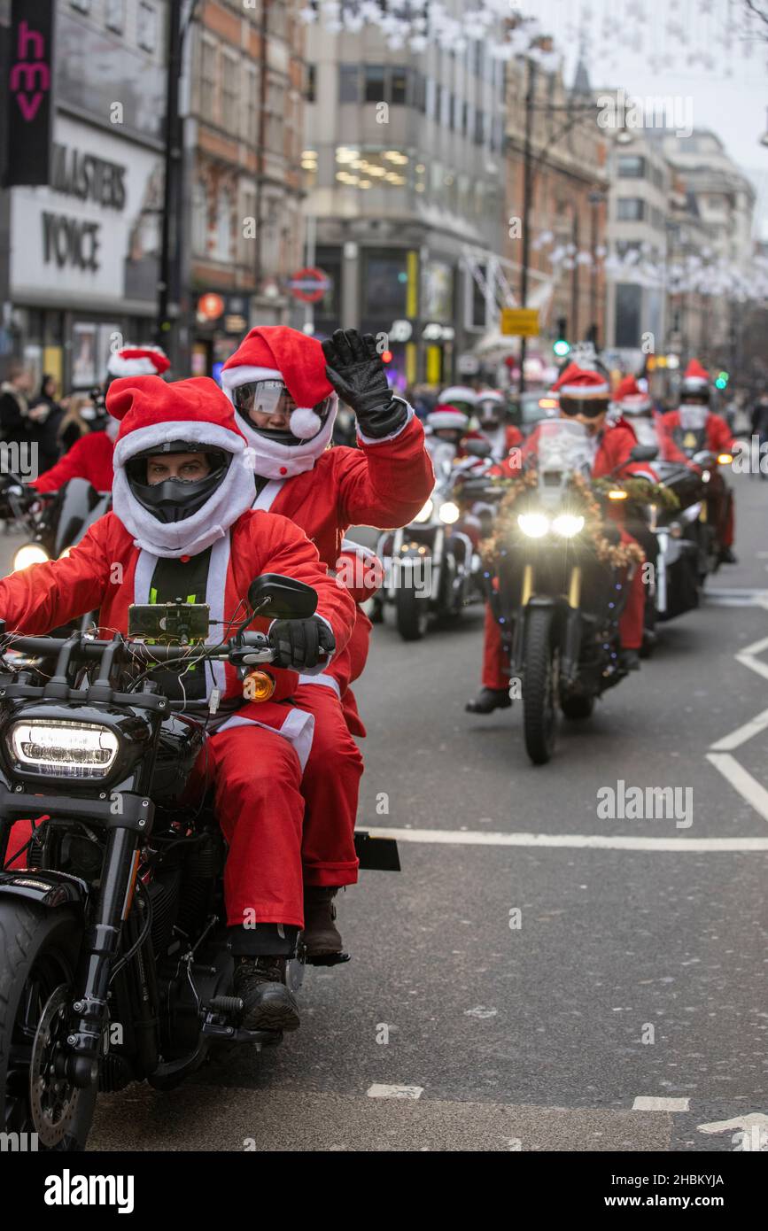 I motociclisti di Santa si sfilano su Oxford Street prima del giorno di Natale, mentre i casi Omicron continuano a spirale prima delle festività. Foto Stock