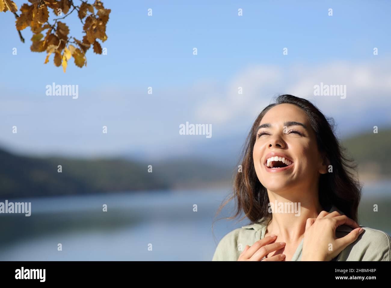 Felice donna di bellezza ridendo all'aperto in natura guardando sopra Foto Stock