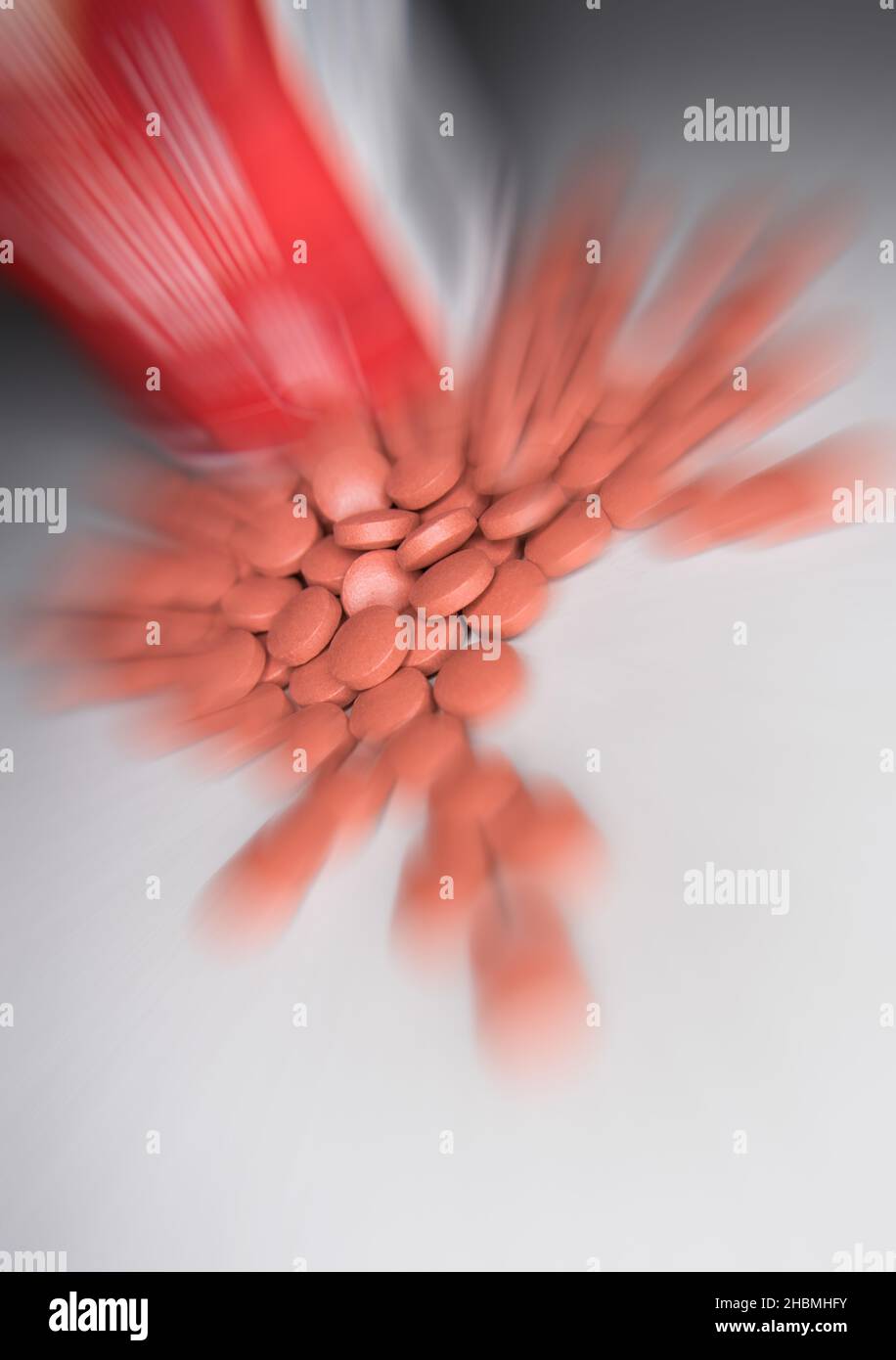 mucchio di pillole rosse su sfondo bianco Foto Stock
