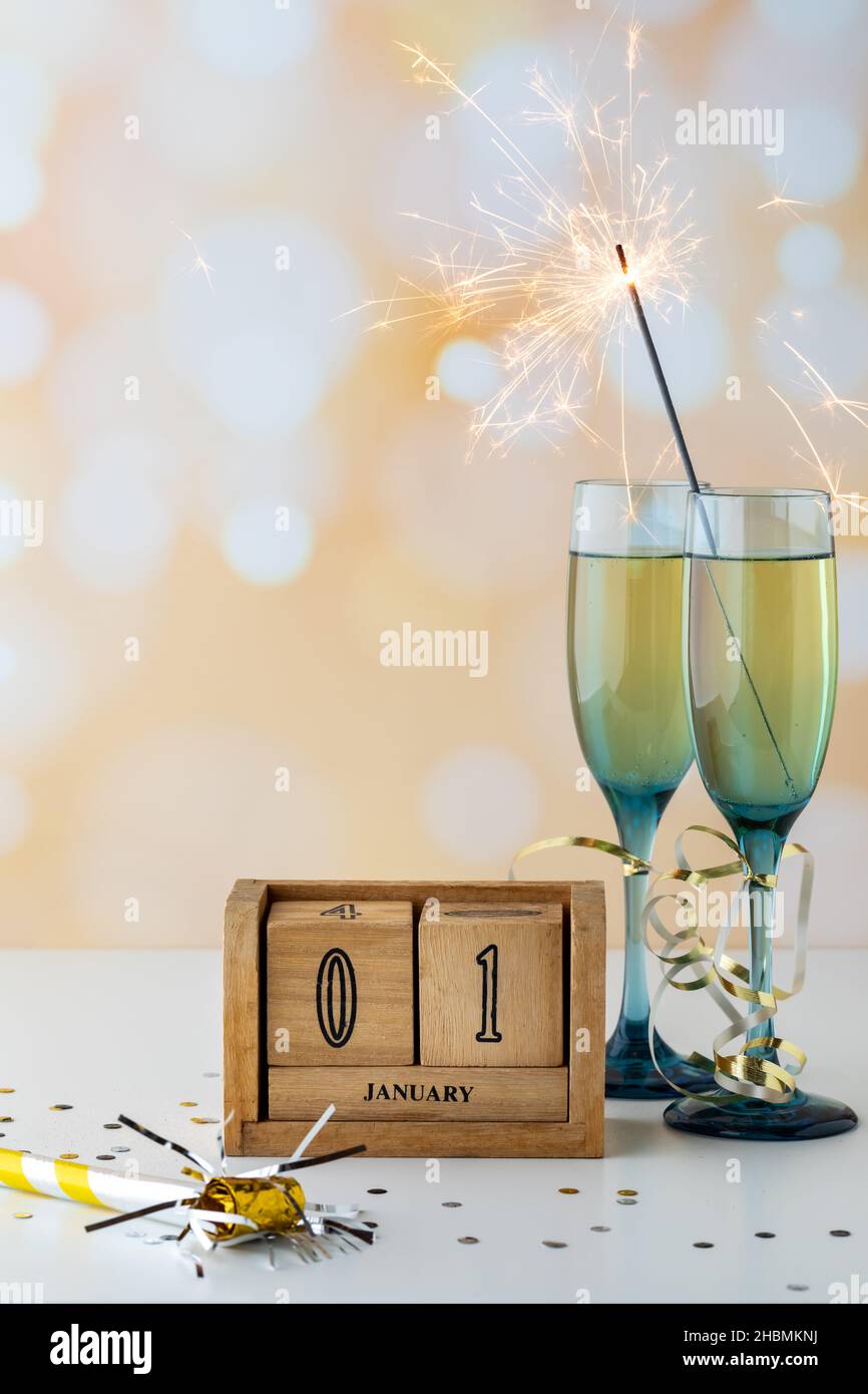 Accordi di champagne di fine anno con sparkler e blocco di date del 1st gennaio. Foto Stock
