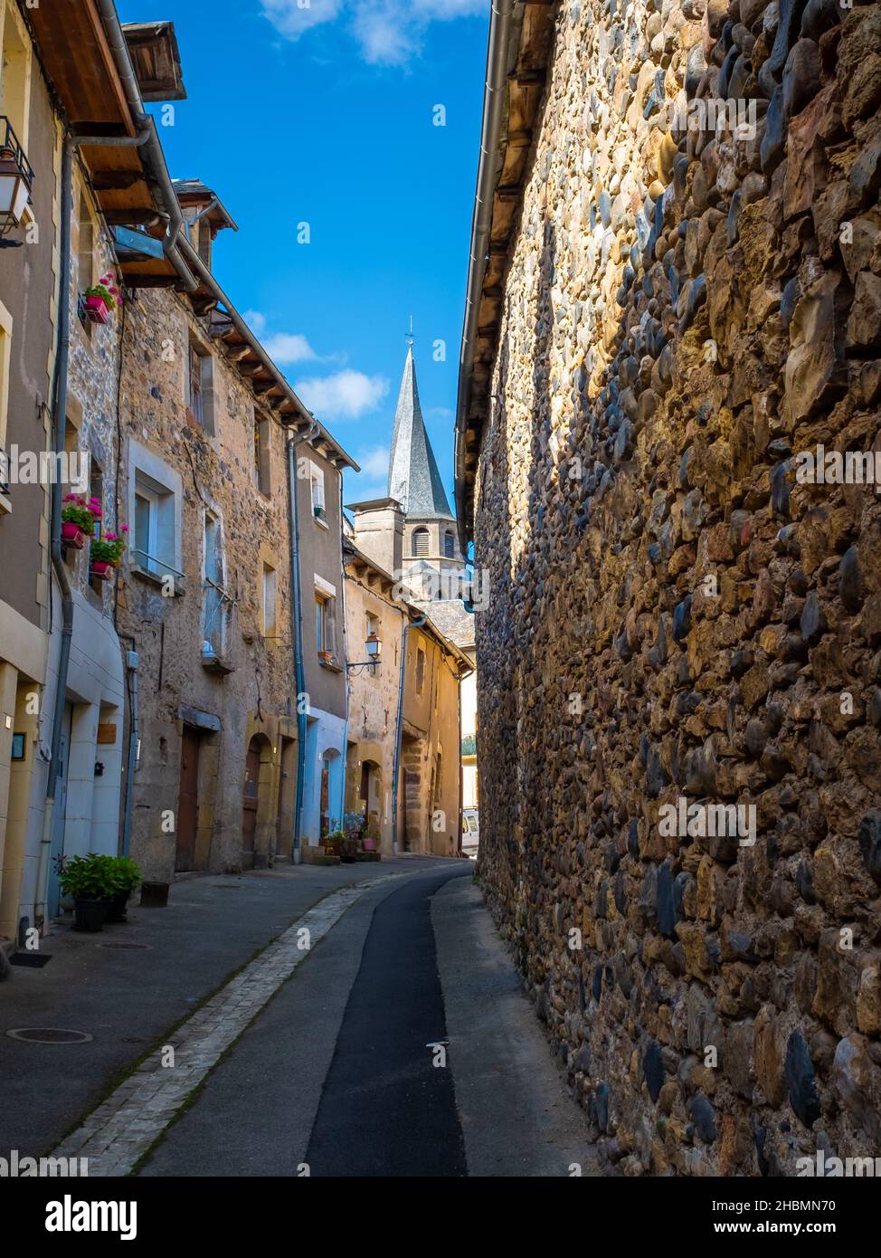 Strada tortuosa della città vecchia di Saint-Côme-d'Olt nel sud-ovest della Francia senza persone prese durante un soleggiato pomeriggio estivo. Foto Stock