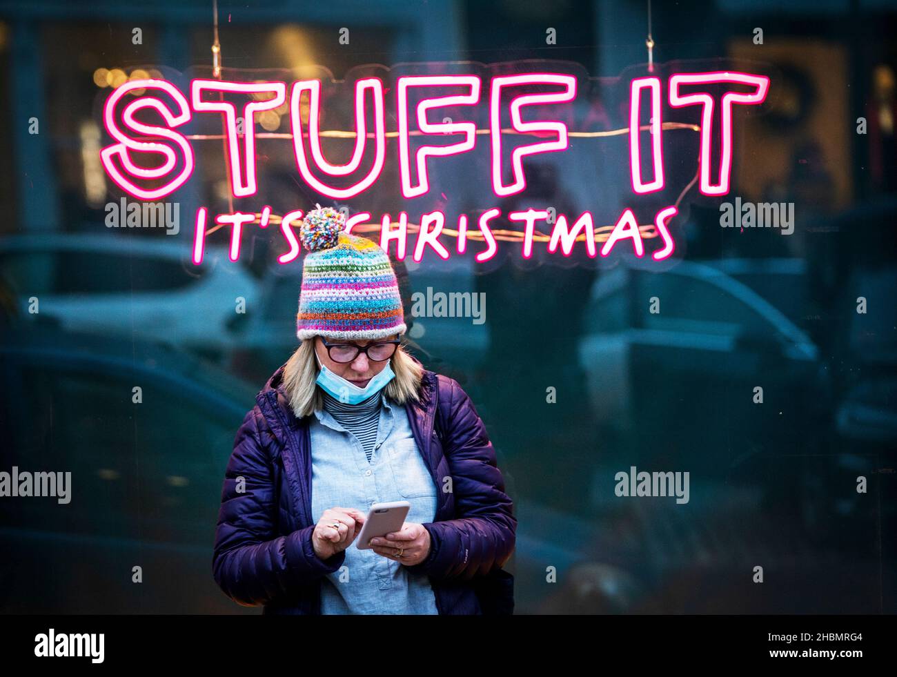 Uno shopper si trova di fronte a un cartello con la scritta "Stuff it, it's Christmas" a George Street, Edimburgo, in quanto il governo ha rifiutato di escludere l'introduzione di ulteriori restrizioni per rallentare la diffusione della variante Omicron del coronavirus. Data foto: Lunedì 20 dicembre 2021. Foto Stock