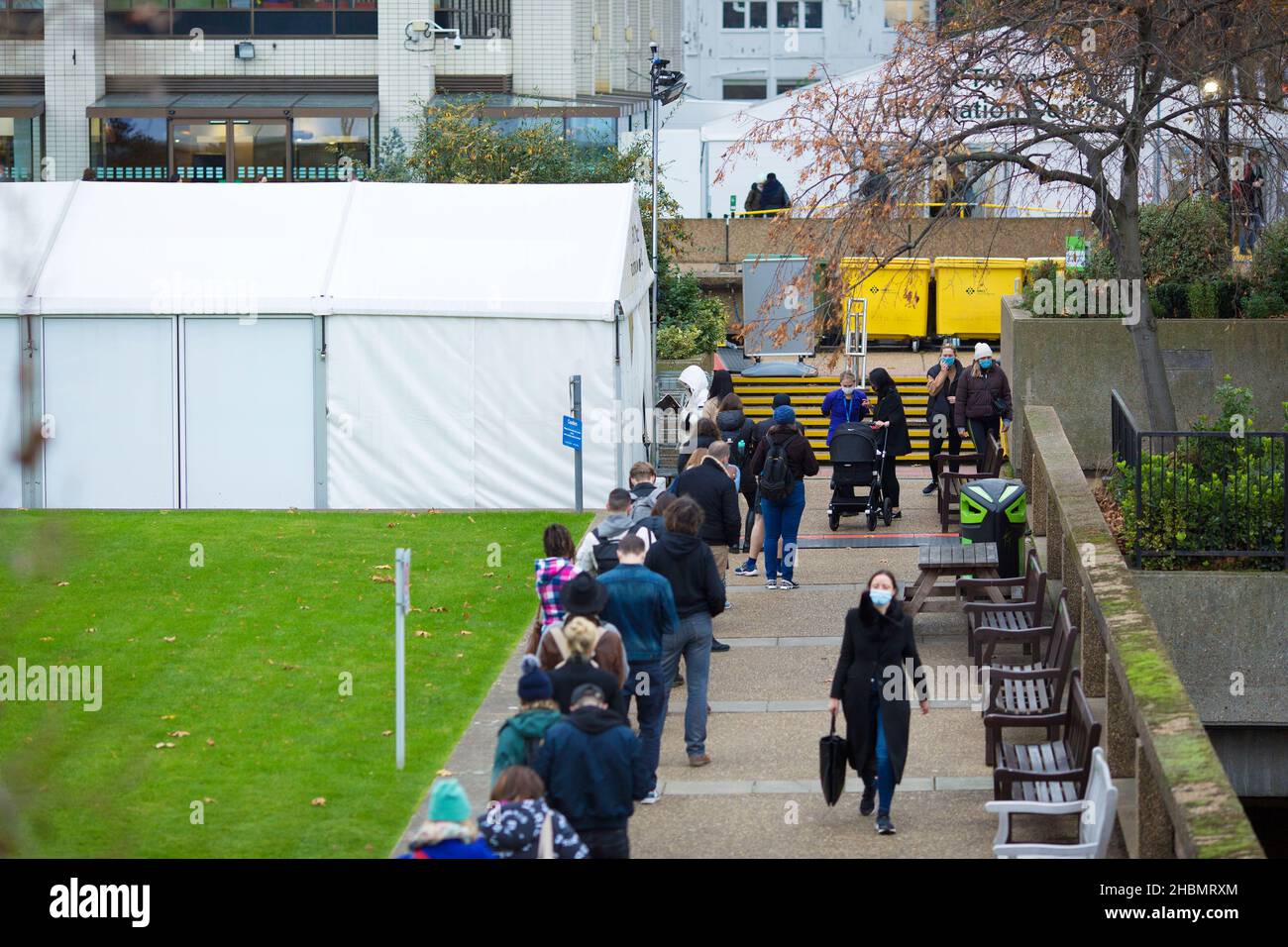 Le persone sono viste fare la fila verso un centro di vaccinazione al St Thomas’ Hospital nel centro di Londra. Foto Stock