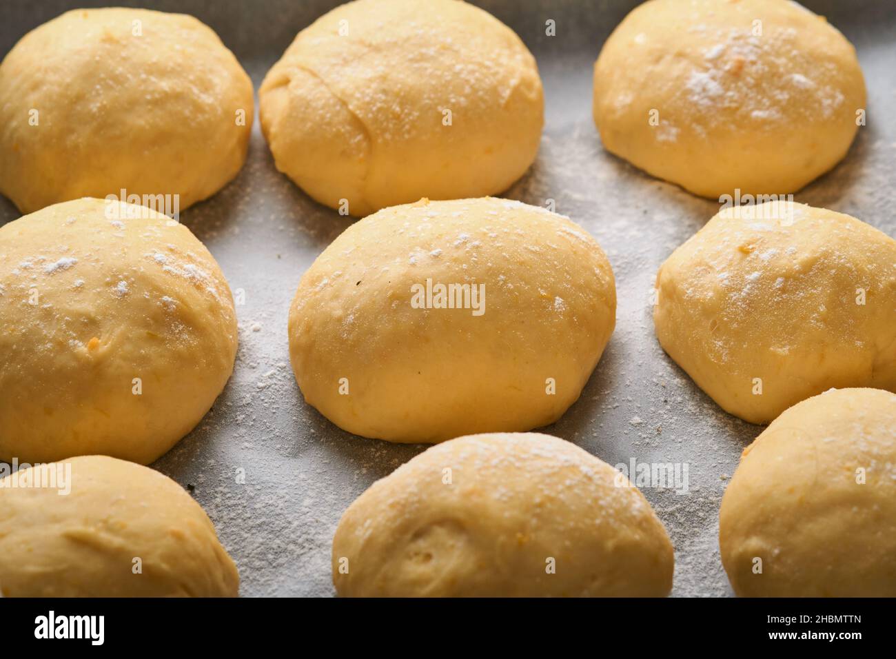 Prima della cottura, preparare le palle di pasta di lievito crudo sullo sfondo della padella. Concetto di casa cottura del pane, panini o cinnabon o fare l'impasto. Foto Stock