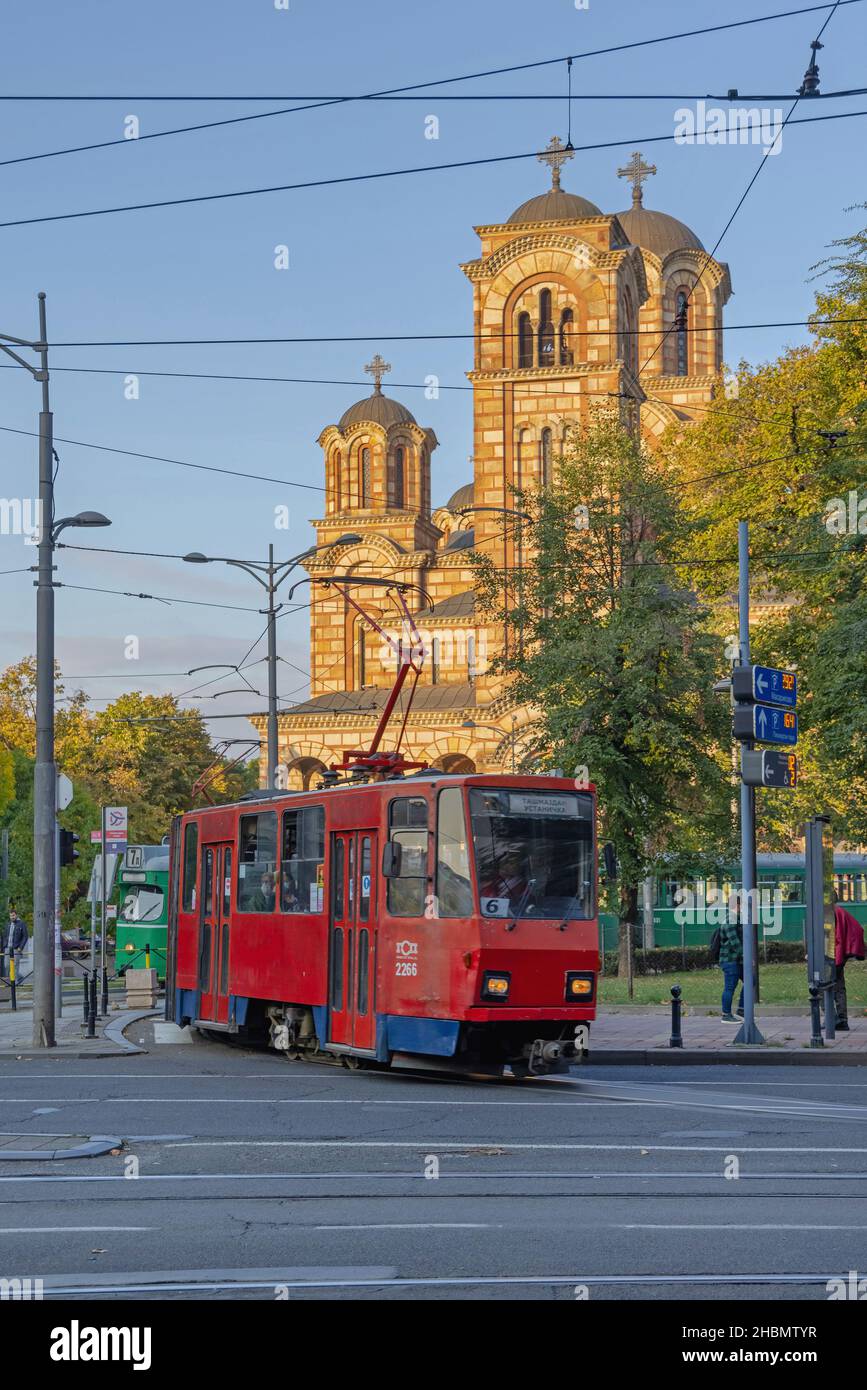 Belgrado, Serbia - 01 ottobre 2021: Vecchio tram rosso di fronte alla Chiesa ortodossa di San Marko, soleggiato pomeriggio d'autunno. Foto Stock