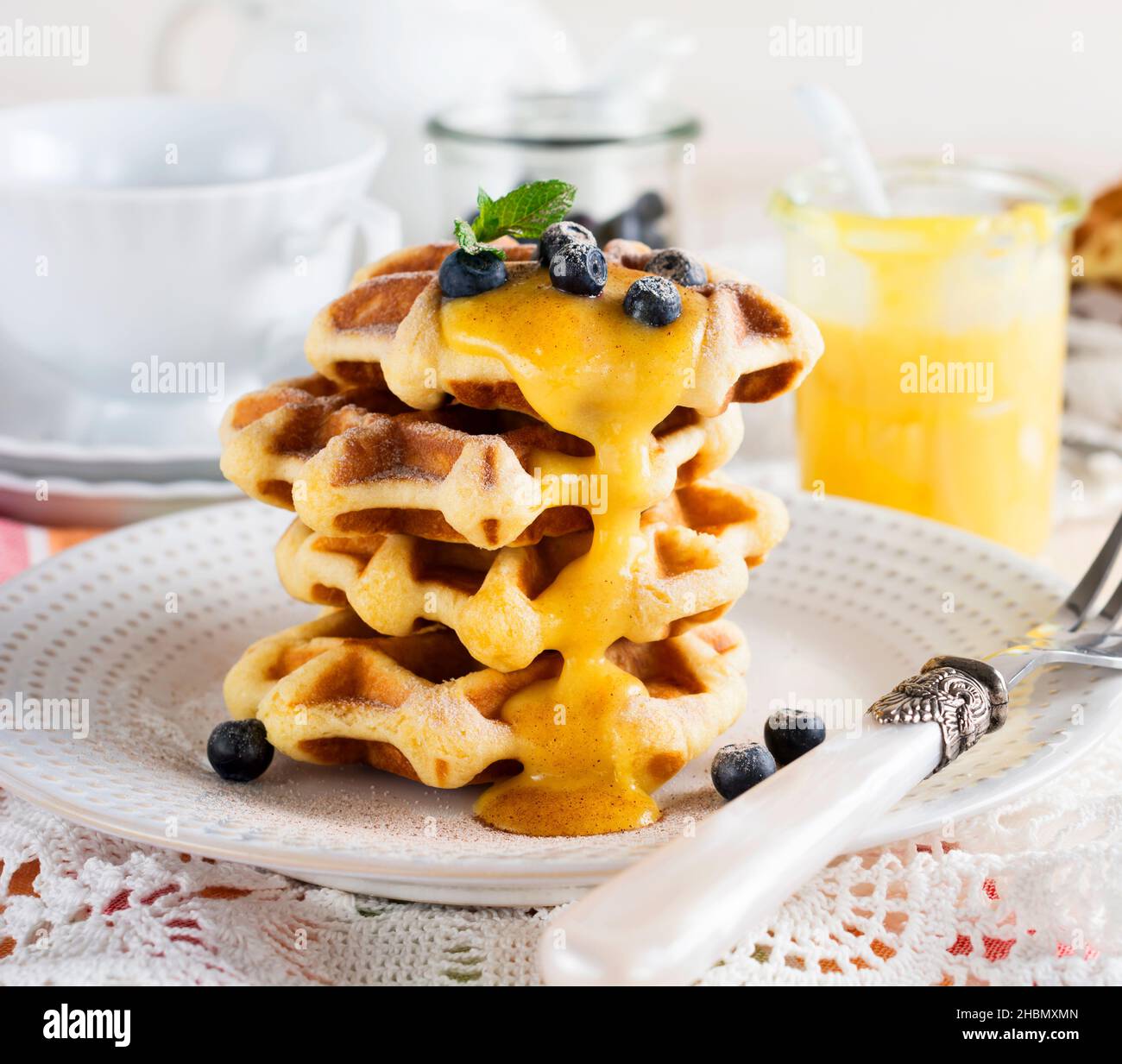 Waffle belgi al limone Kurd e mirtilli. Stile rustico. Messa a fuoco selettiva. Foto Stock