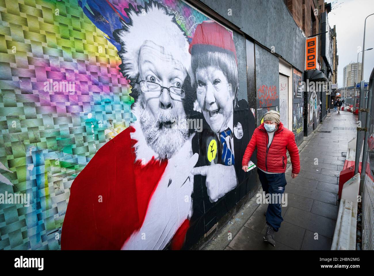 Un membro del pubblico cammina davanti a un poster che presenta Babbo Natale e Wee Jimmy Krankie a Leith Walk, Edimburgo, in quanto il governo si rifiutò di escludere l'introduzione di ulteriori restrizioni per rallentare la diffusione della variante Omicron del coronavirus. Data foto: Lunedì 20 dicembre 2021. Foto Stock