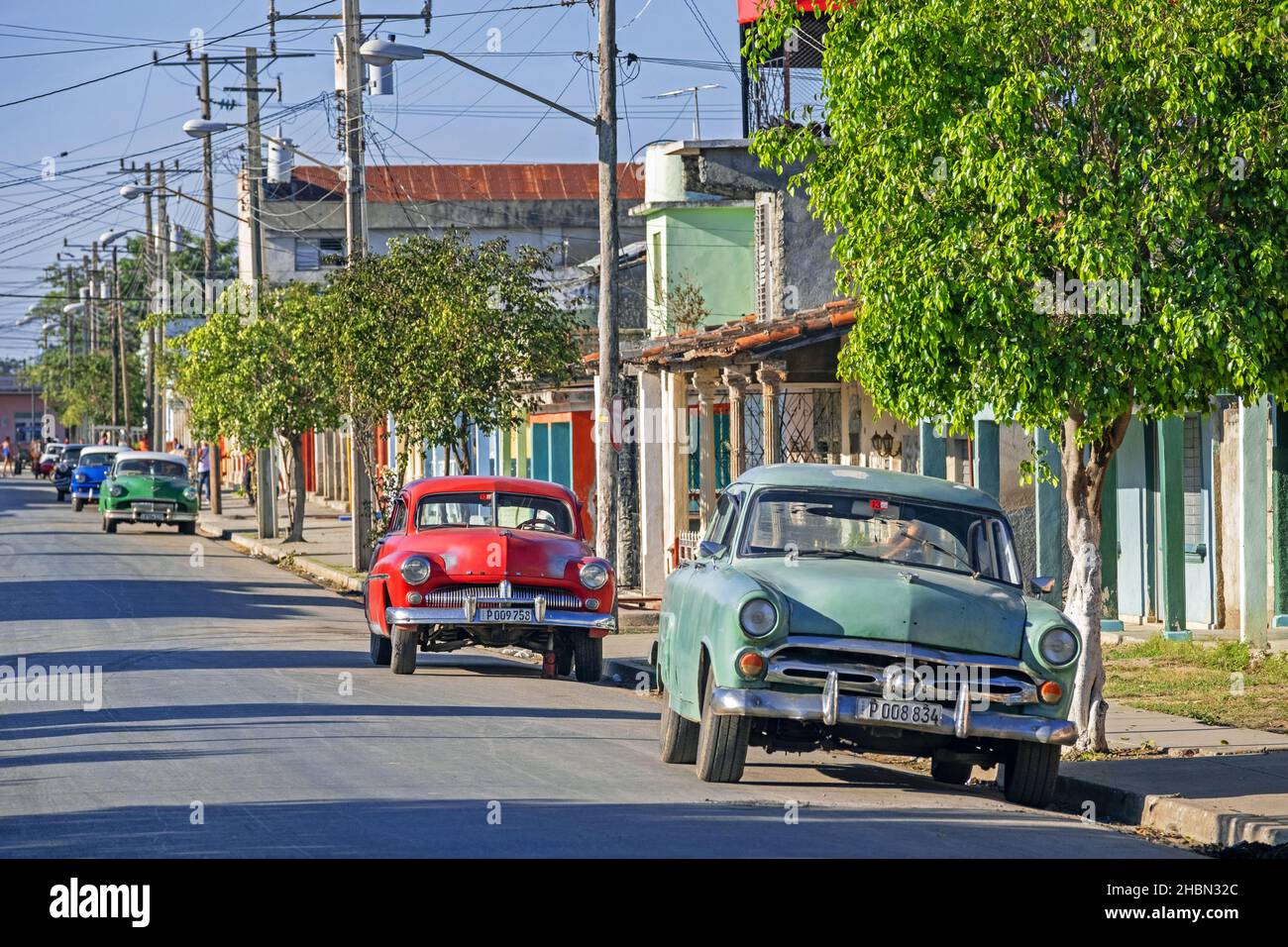 Auto classiche americane parcheggiate lungo la strada nella città di Ranchuelo nella provincia di Villa Clara sull'isola Cuba, Caraibi Foto Stock