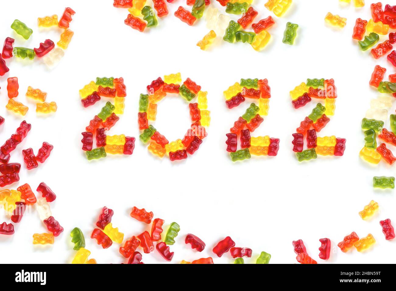 2022 realizzato con colorati orsi gommosi e più gengive intorno, dolce biglietto di auguri felice anno nuovo, isolato con piccole ombre su sfondo bianco Foto Stock