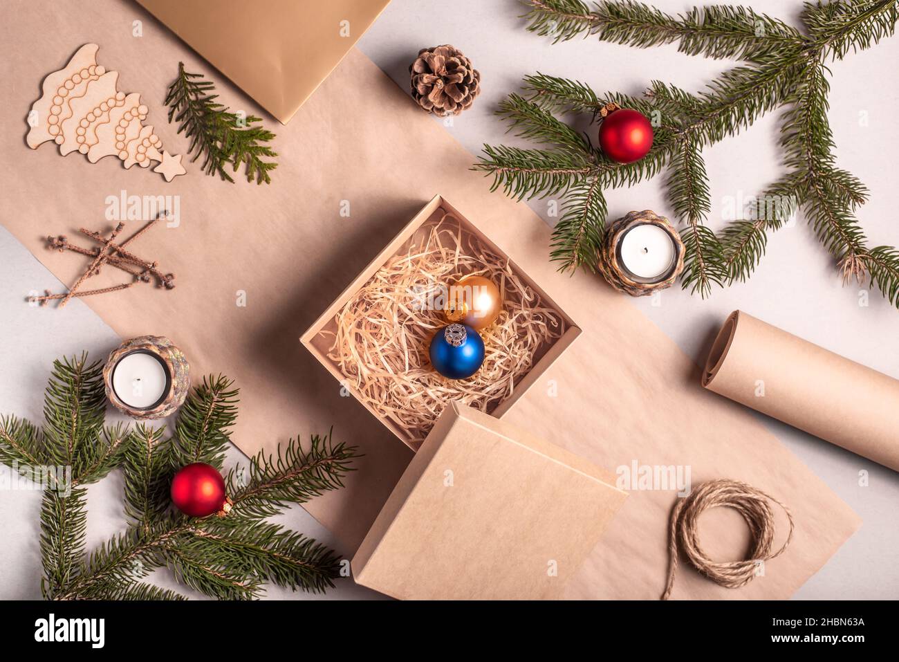 Imballaggio di un regalo per Natale e Capodanno in materiali eco-compatibili: Carta kraft, rami di abete vivo, cono, spago. Tag con mock up, arredamento naturale Foto Stock