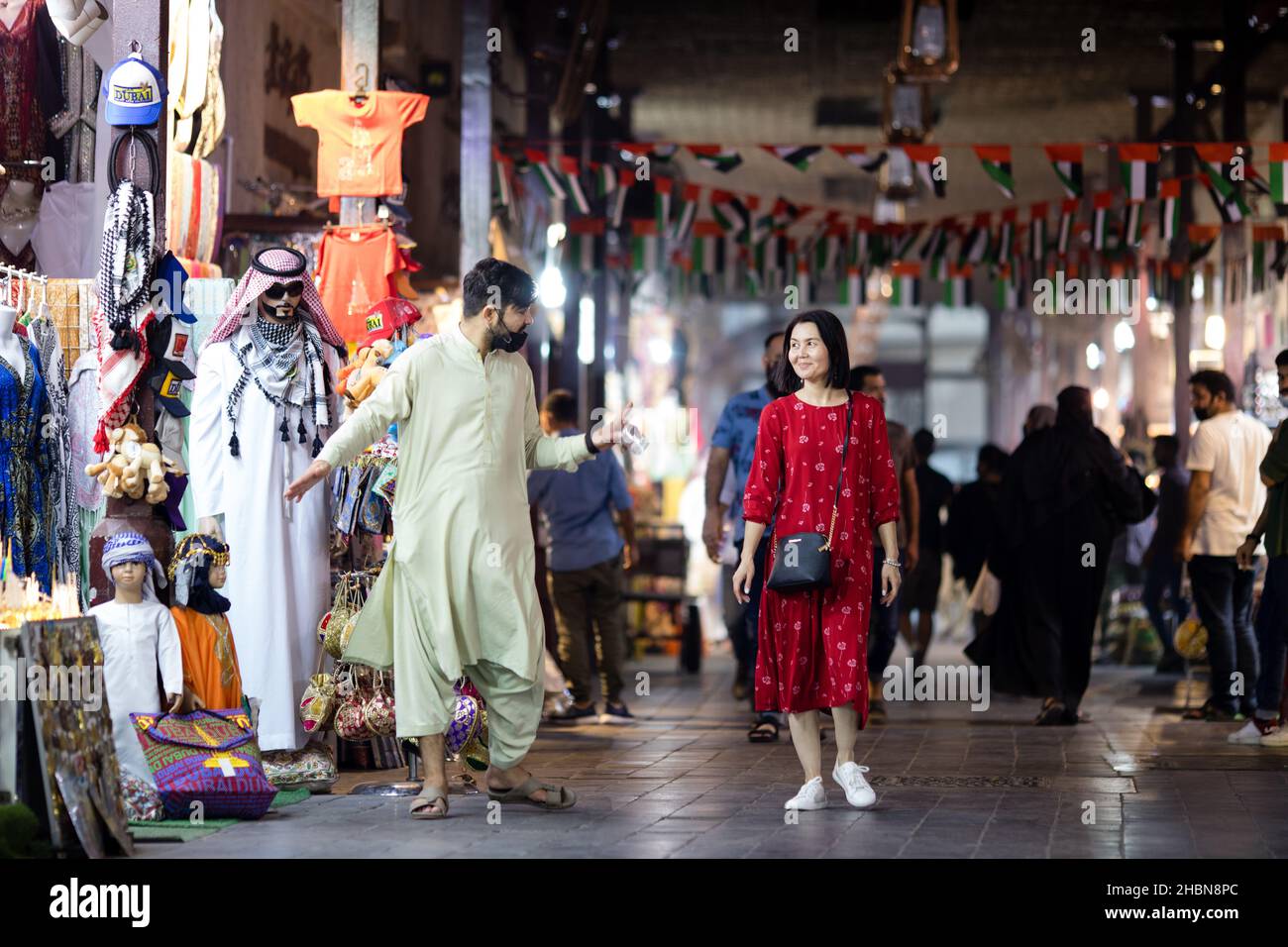 Un turista che cammina attraverso il Grand Souk di Bur Dubai negli Emirati Arabi Uniti. Foto Stock