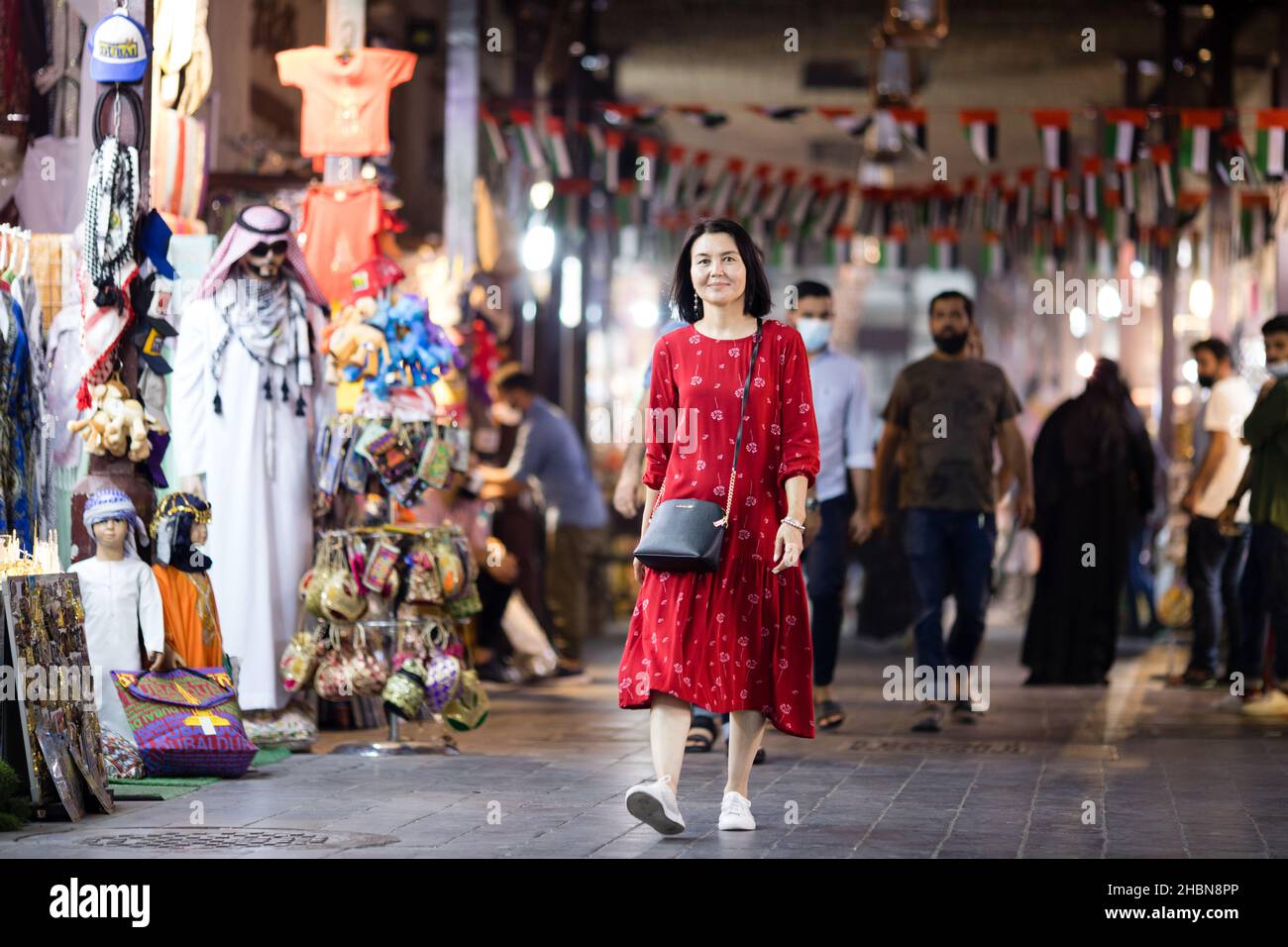 Un turista che cammina attraverso il Grand Souk di Bur Dubai negli Emirati Arabi Uniti. Foto Stock