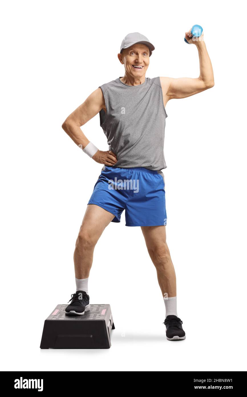 Ritratto a tutta lunghezza di un uomo anziano in abbigliamento sportivo che si esercita con una piattaforma aerobica step e un piccolo peso isolato su sfondo bianco Foto Stock