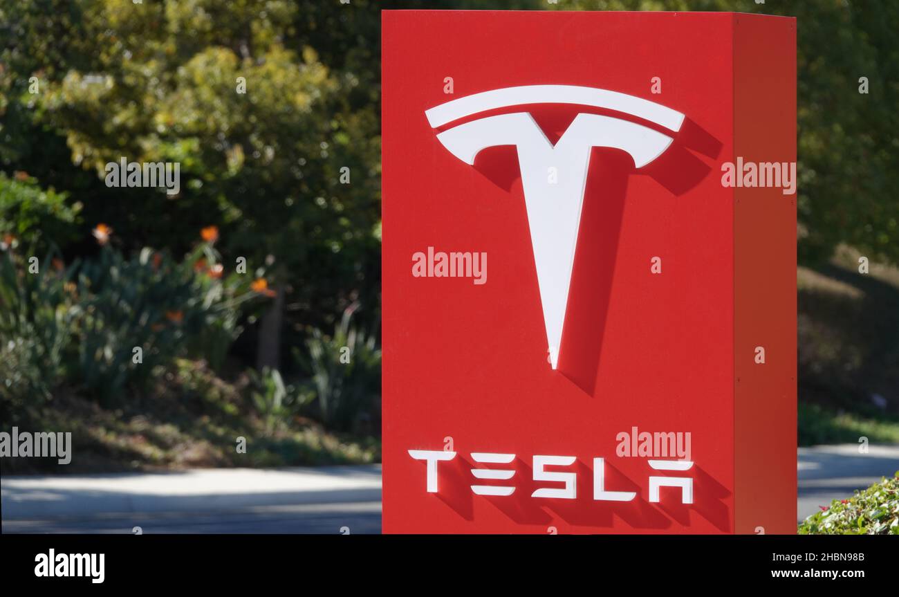 Carlsbad, CA USA - 12 dicembre 2021: Primo piano del logo Tesla su un cartello presso una concessionaria Foto Stock