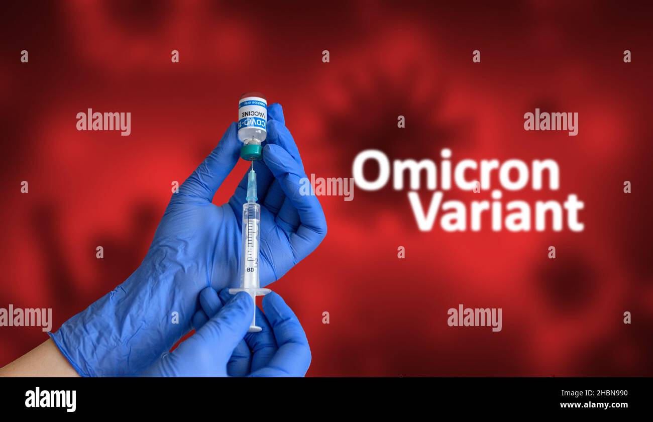 Operatore medico con guanti blu che tengono la siringa e che estrae il vaccino contro il coronavirus dal flaconcino di fronte al fondo rosso con testo omicron sars-COV-2 Foto Stock