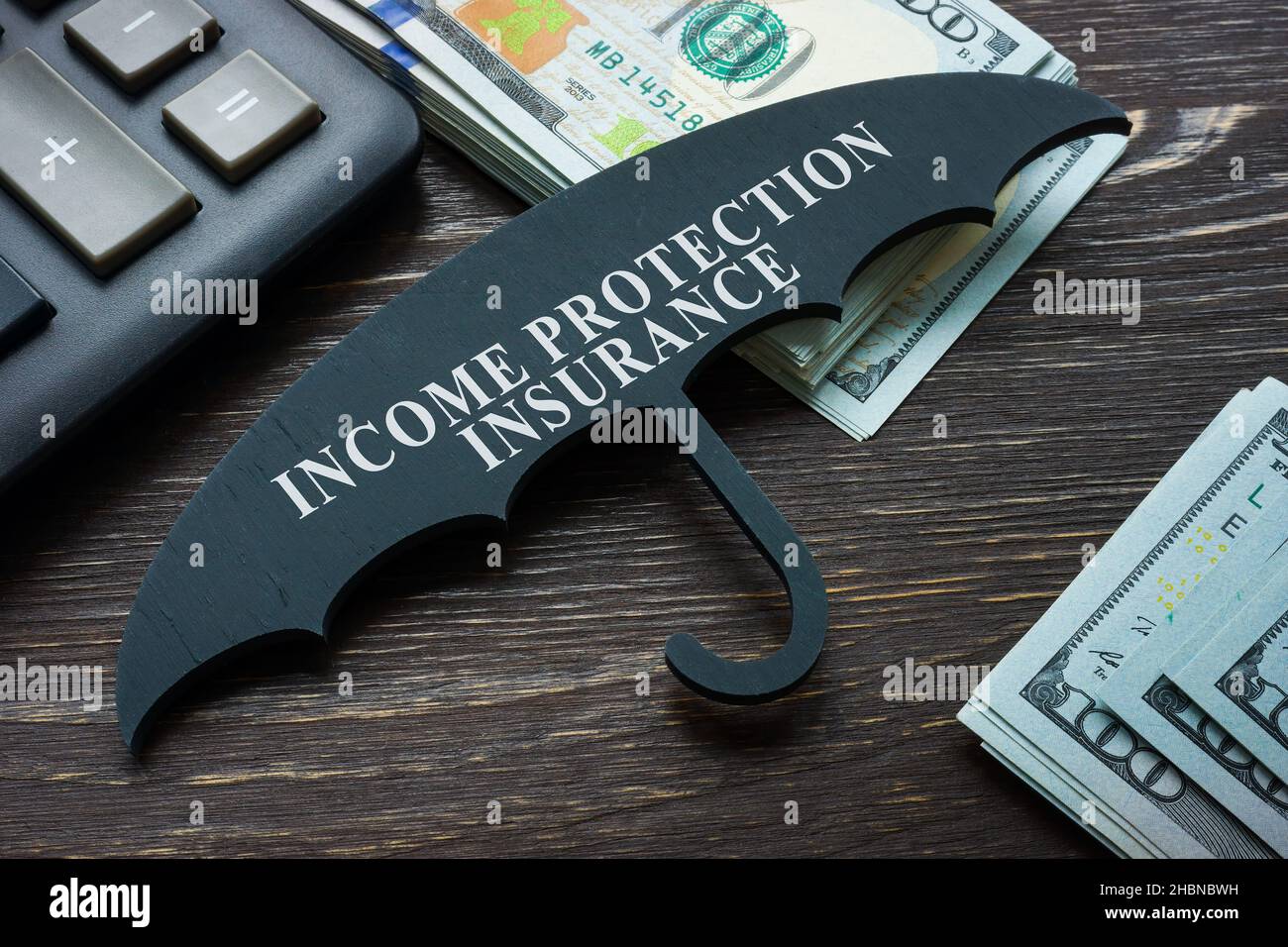 Ombrello con segno assicurazione di protezione del reddito e denaro. Foto Stock