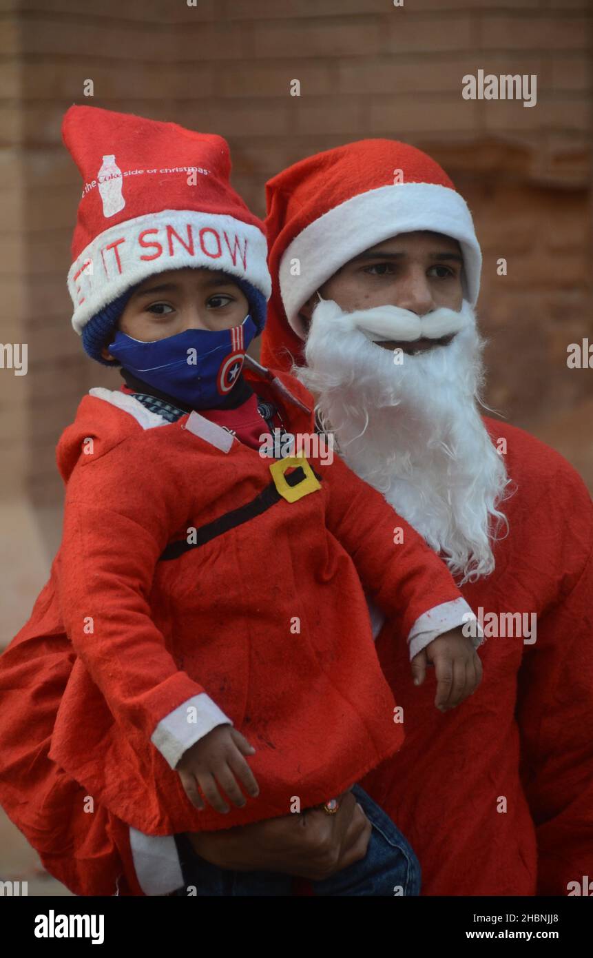 Peshawar, Pakistan. 20th Dic 2021. I membri della minoranza cristiana pakistana vestita come clausole di Santa prendono parte ad un raduno pre-Natale su una strada a Peshawar. Il Pakistan è un paese musulmano a maggioranza sunnita con quattro milioni di cristiani su una popolazione totale di circa 200 milioni di abitanti. (Foto di Hussain Ali/Pacific Press) Credit: Pacific Press Media Production Corp./Alamy Live News Foto Stock