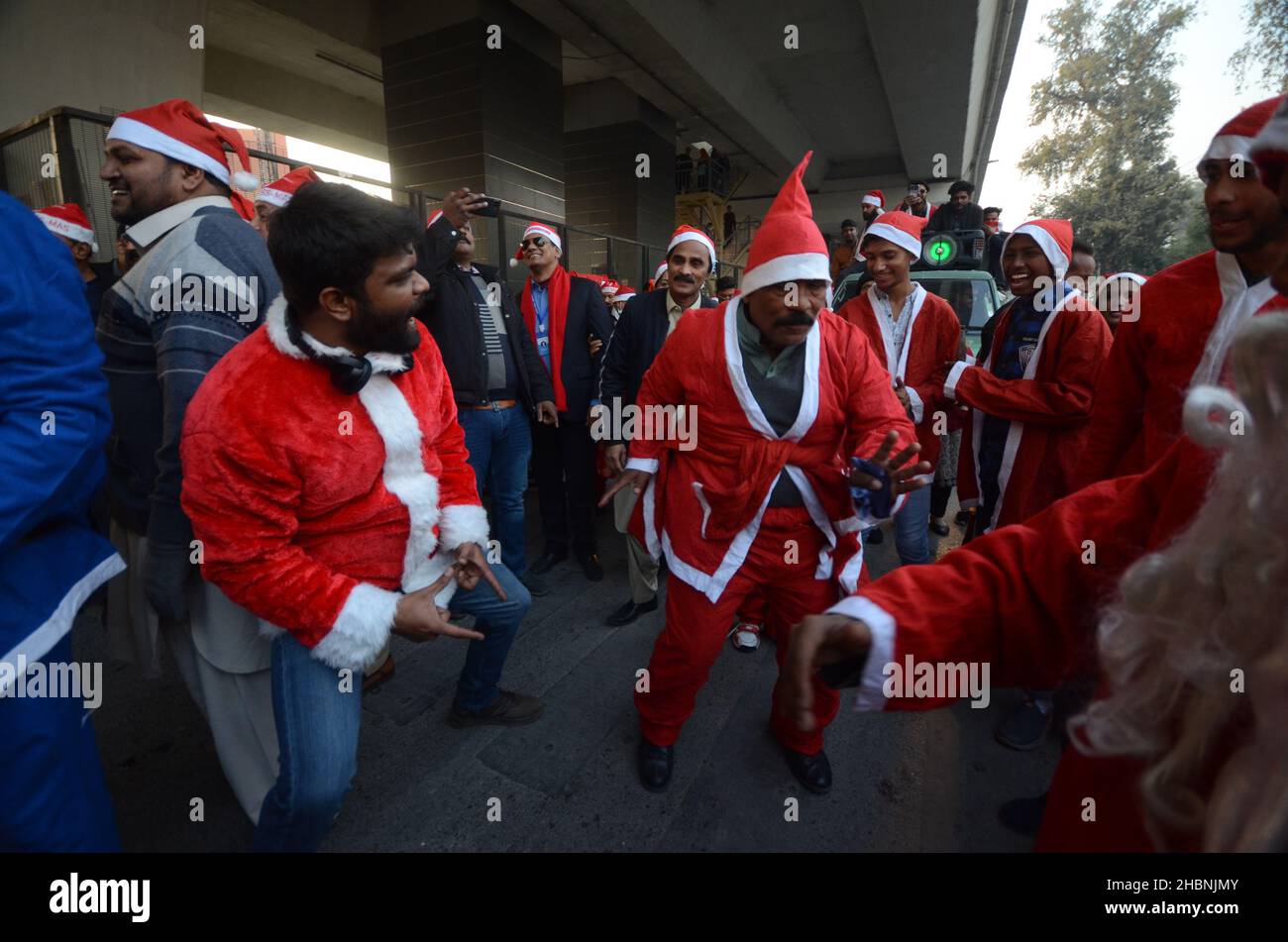 Peshawar, Pakistan. 20th Dic 2021. I membri della minoranza cristiana pakistana vestita come clausole di Santa prendono parte ad un raduno pre-Natale su una strada a Peshawar. Il Pakistan è un paese musulmano a maggioranza sunnita con quattro milioni di cristiani su una popolazione totale di circa 200 milioni di abitanti. (Foto di Hussain Ali/Pacific Press) Credit: Pacific Press Media Production Corp./Alamy Live News Foto Stock