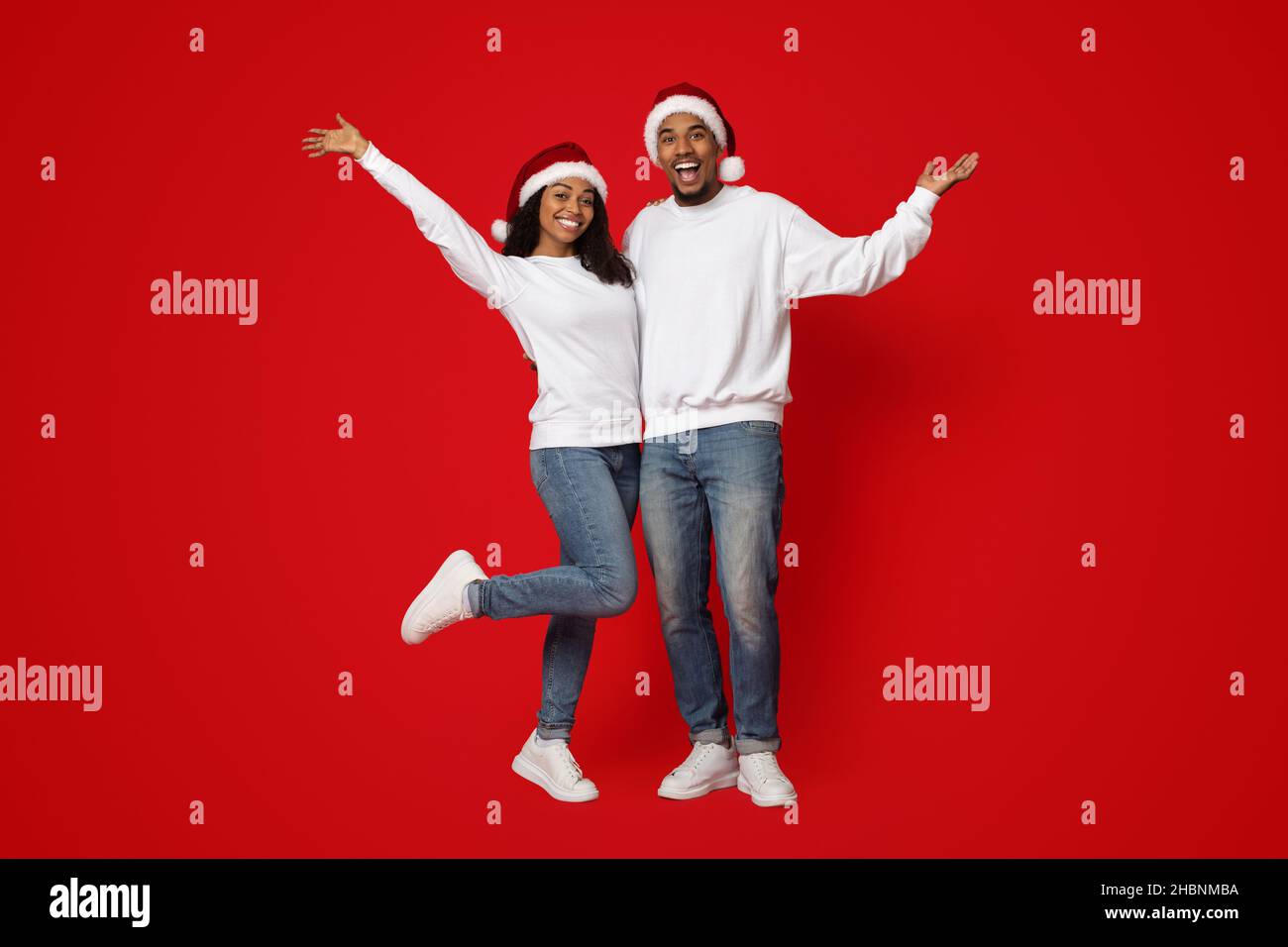 Felice amerian amanti africani a Babbo Natale cappelli divertirsi Foto Stock