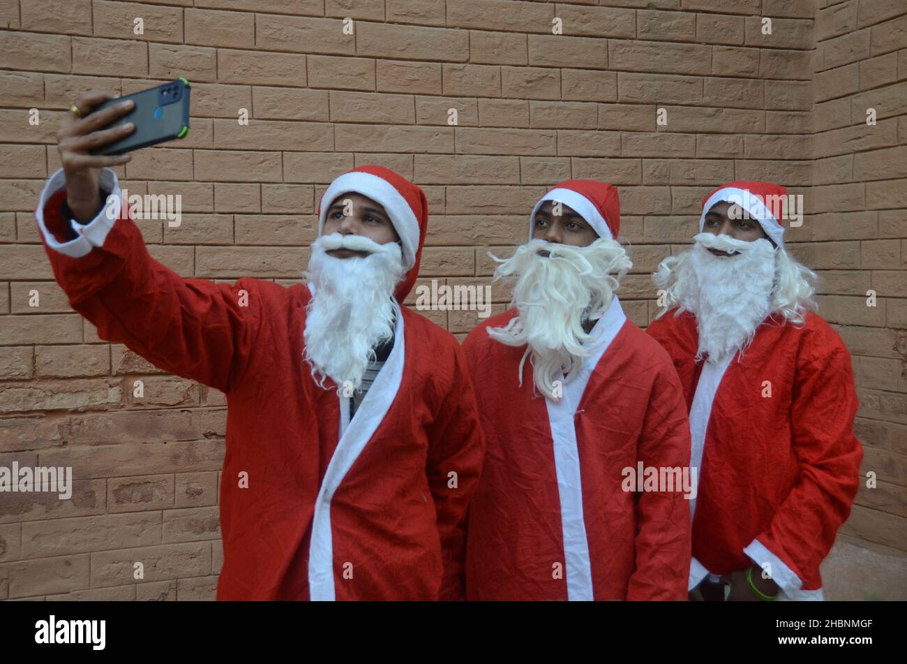 Peshawar, Peshawar, Pakistan. 20th Dic 2021. I membri della minoranza cristiana pakistana vestita come clausole di Santa prendono parte ad un raduno pre-Natale su una strada a Peshawar. Il Pakistan è un paese musulmano a maggioranza sunnita con quattro milioni di cristiani su una popolazione totale di circa 200 milioni di abitanti. (Credit Image: © Hussain Ali/Pacific Press via ZUMA Press Wire) Foto Stock