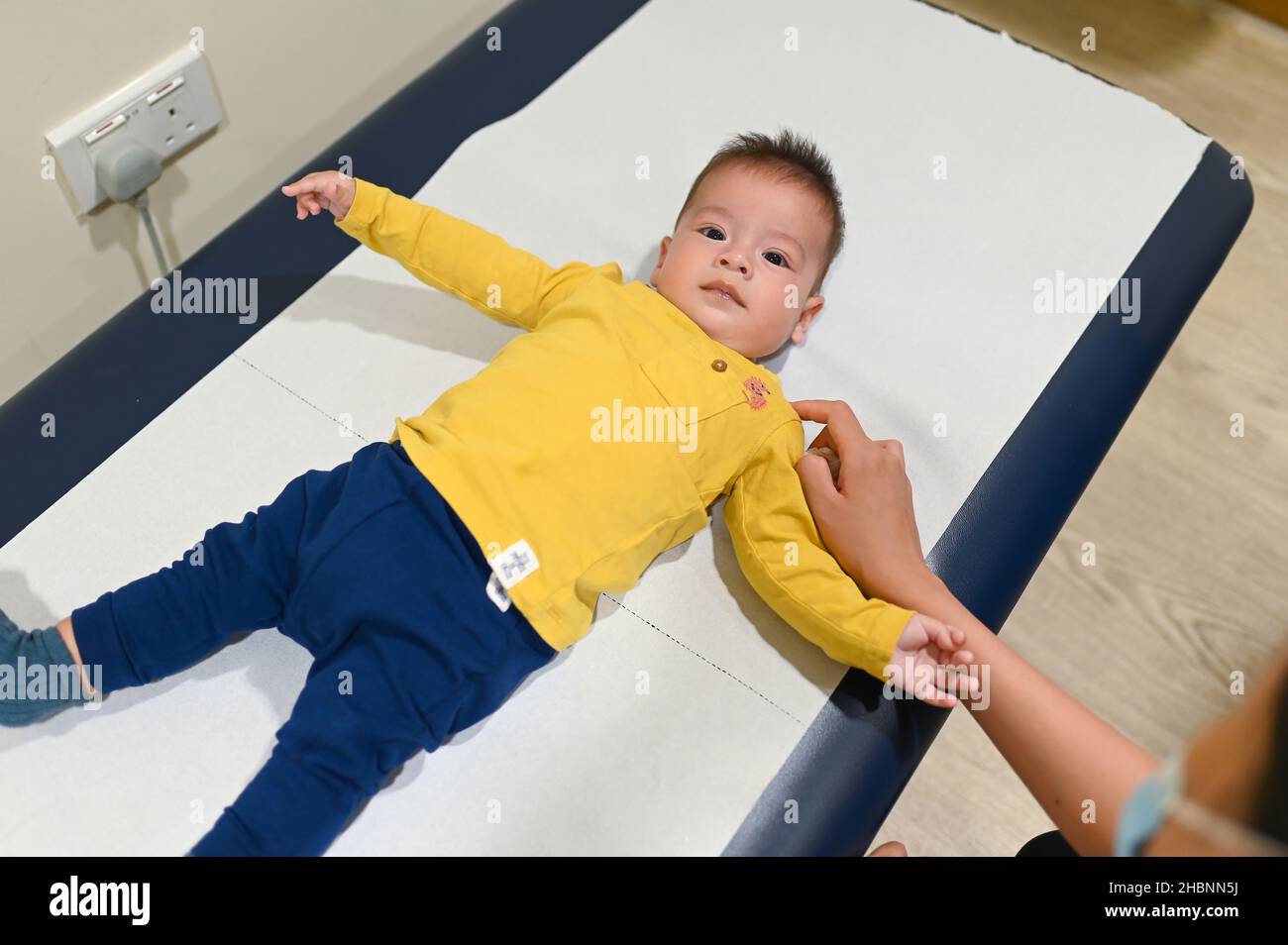 bambino di 5 mesi di razza mista presso l'ufficio dei medici per un controllo di routine e un esame fisico per monitorare i progressi in ospedale Foto Stock