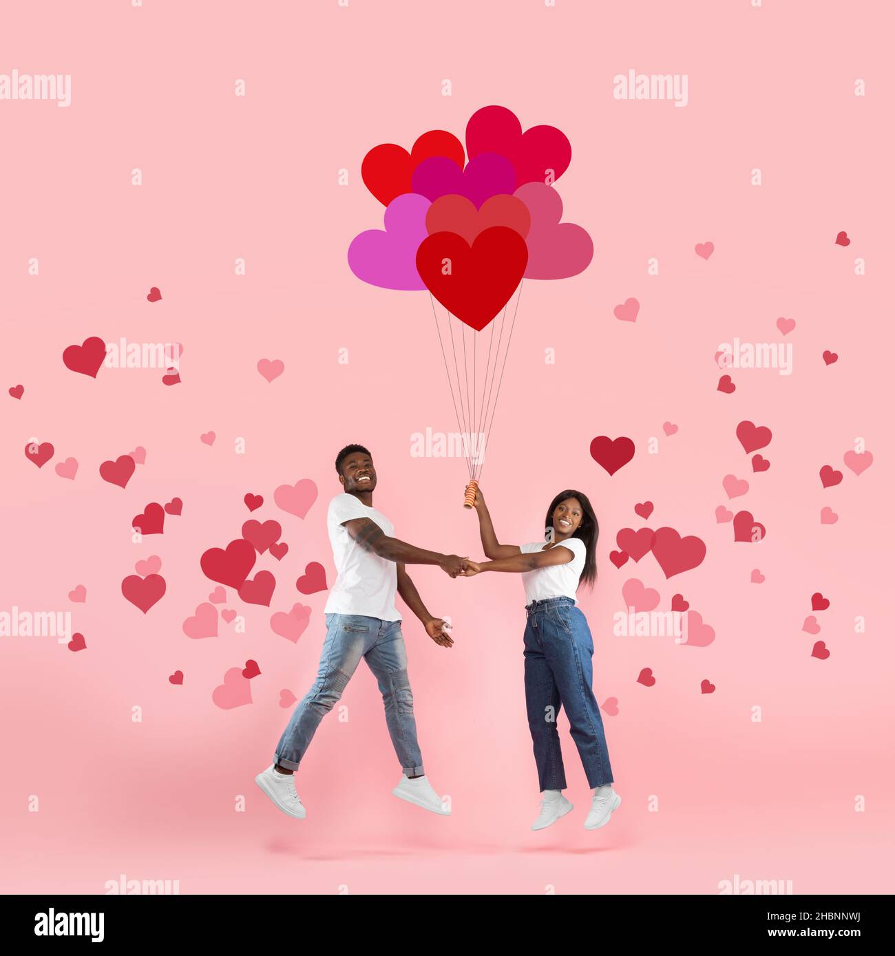 Giovane Romantico Nero Coppia Flying Holding Balloons Foto Stock