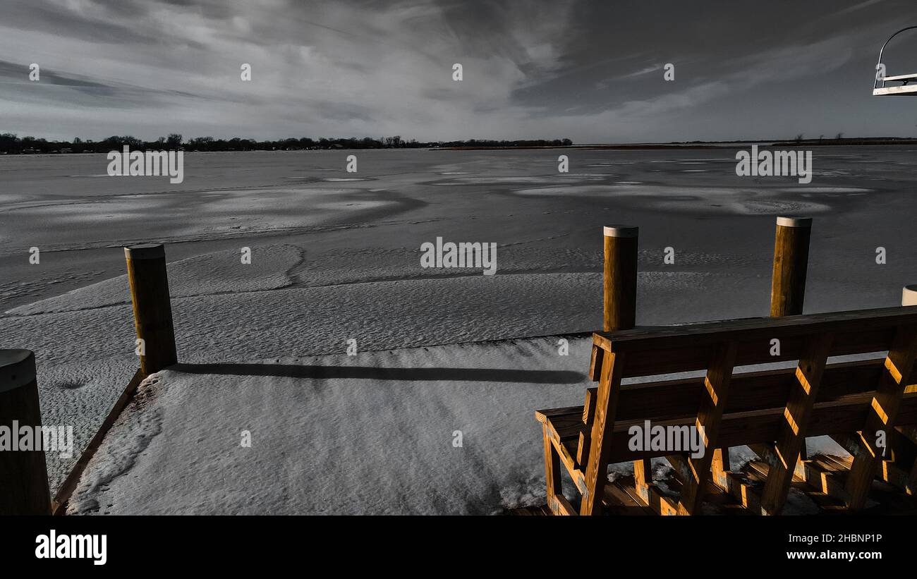 Prendi posto sulla panchina e goditi la vista della ghiacciata terra invernale. Il lago Winneconne è ghiacciato con la neve fresca sbarcare il giorno prima. Dicembre 2021 Foto Stock