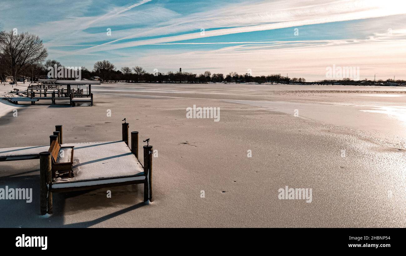 Fila di banchine sono allineate sulla riva del lago Winneconne nella campagna del Wisconsin. Il sole è luminoso e scioglie la neve subito dopo una fresca caduta di neve. Foto Stock