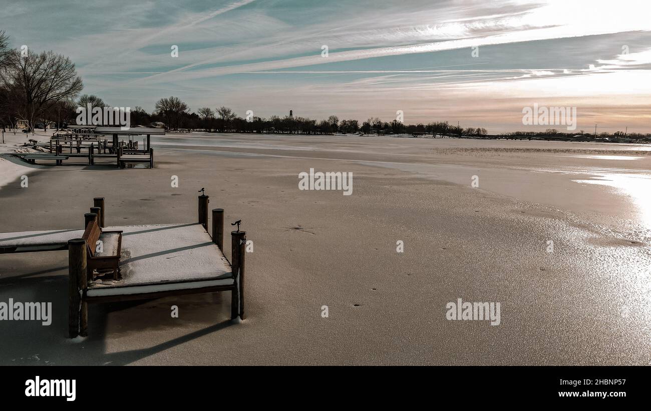 Fila di banchine sono allineate sulla riva del lago Winneconne nella campagna del Wisconsin. Il sole è luminoso e scioglie la neve subito dopo una fresca caduta di neve. Foto Stock