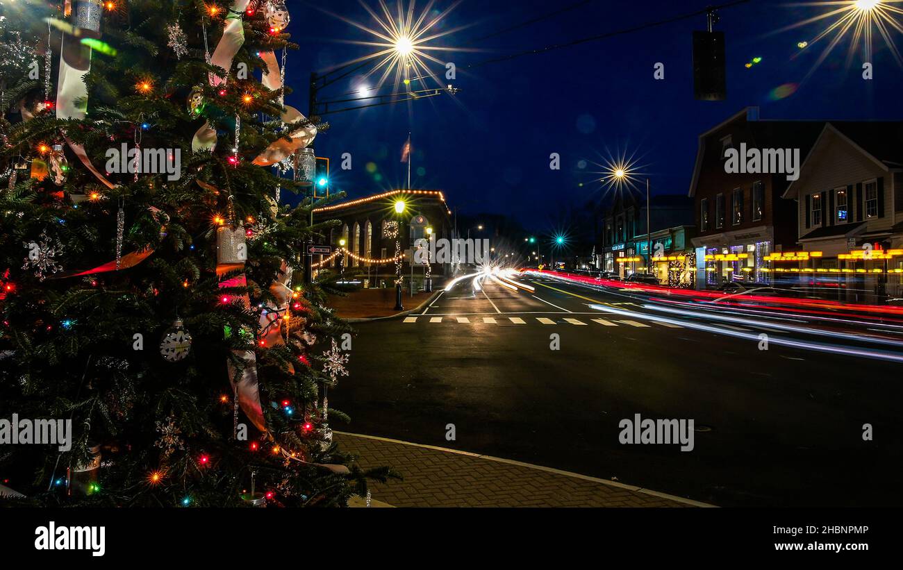 WESTPORT, CT, Stati Uniti d'America - DICEMBRE 17 2021: Albero di Natale vicino a Main Street con traffico su Post Road in centro con luci di festa e Trail luci fr Foto Stock