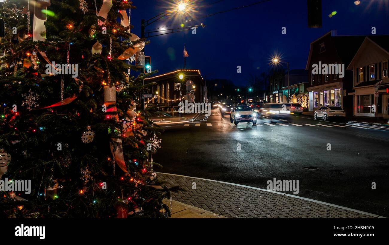 WESTPORT, CT, Stati Uniti d'America - DICEMBRE 17 2021: Albero di Natale vicino a Main Street con traffico su Post Road in centro con luci di festa e Trail luci fr Foto Stock