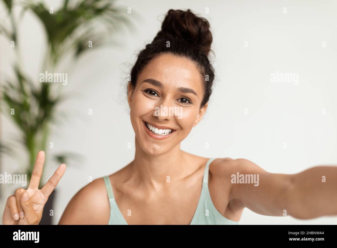 Faccia felice. Giovane allegra bella donna prendendo Selfie e mostrando gesto di Pace Foto Stock