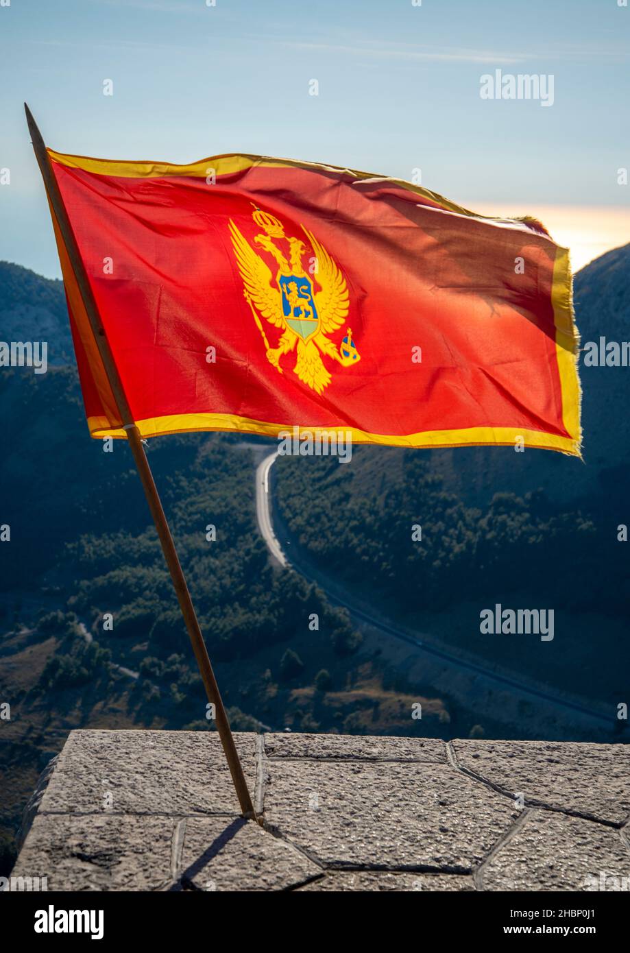Sbattendo nel vento al parco nazionale di Lovcen, in piedi con orgoglio nei colori rosso e oro vicino al Mausoleo di Njegos, un'importante destinazione turistica e la res Foto Stock