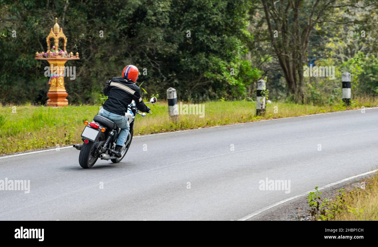 Uomo che guida la sua moto classica al parco nazionale Khao Yai Foto Stock