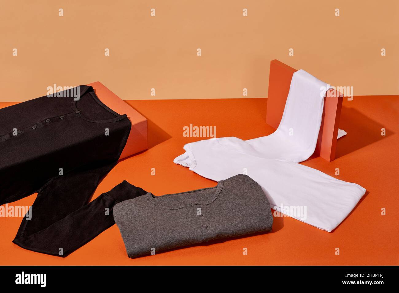 Camicie morbide piegate su sfondo arancione e beige Foto Stock