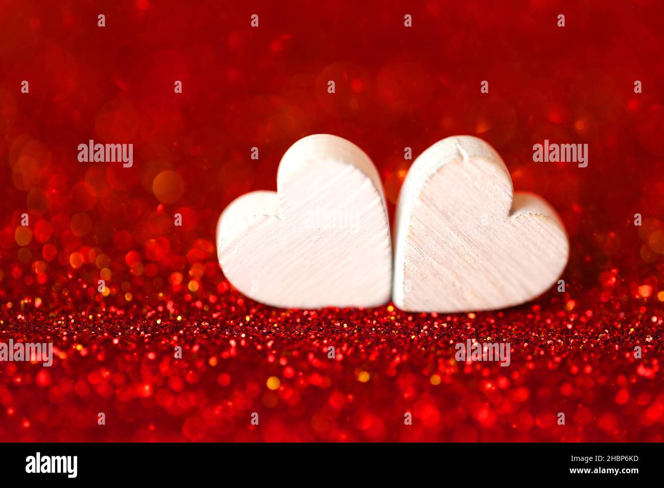 Love Concept.San Valentino. Due cuori bianchi su sfondo glitterato. Sfondo del giorno di San Valentino in toni rossi.simbolo d'amore Foto Stock